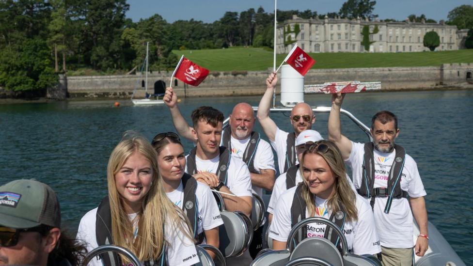 Y baton yn rhuthro ar gwch cyflym ar afon Menai