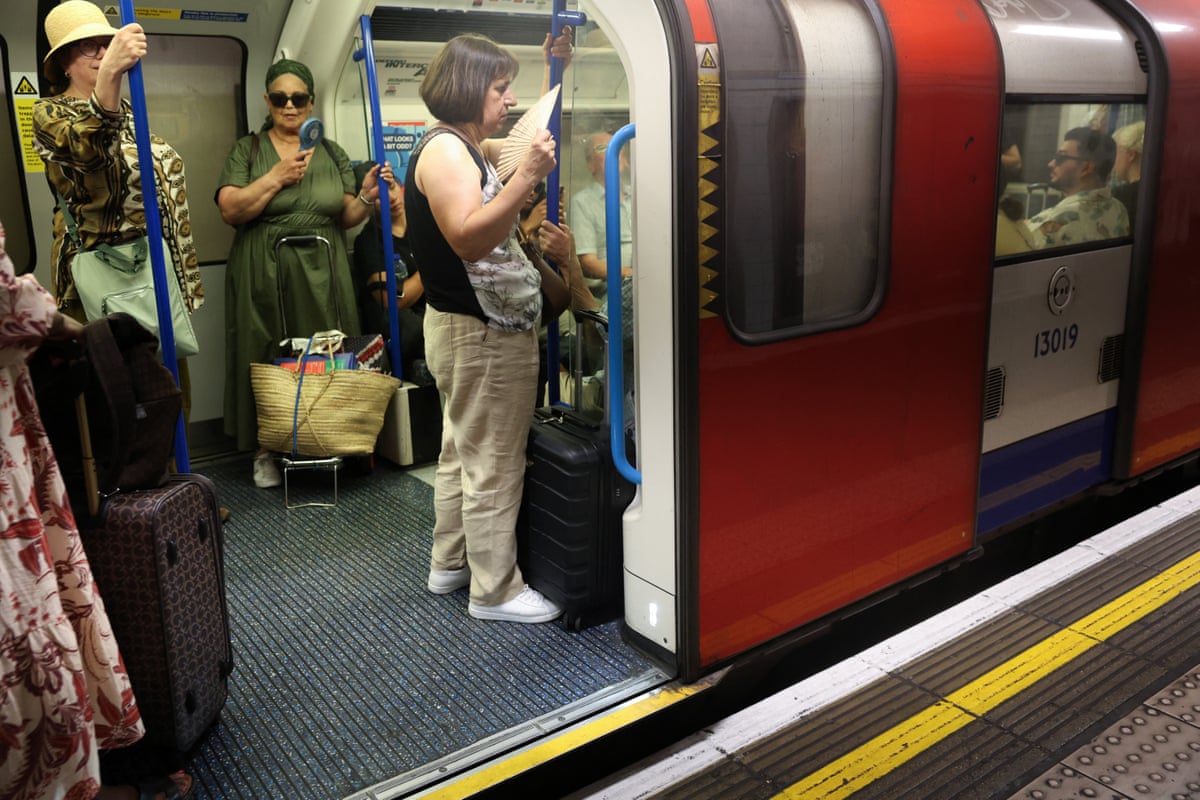People using fans on the tube in central London on Wednesday.