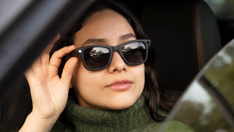 Woman driving a modern car while wearing smart AI sunglasses