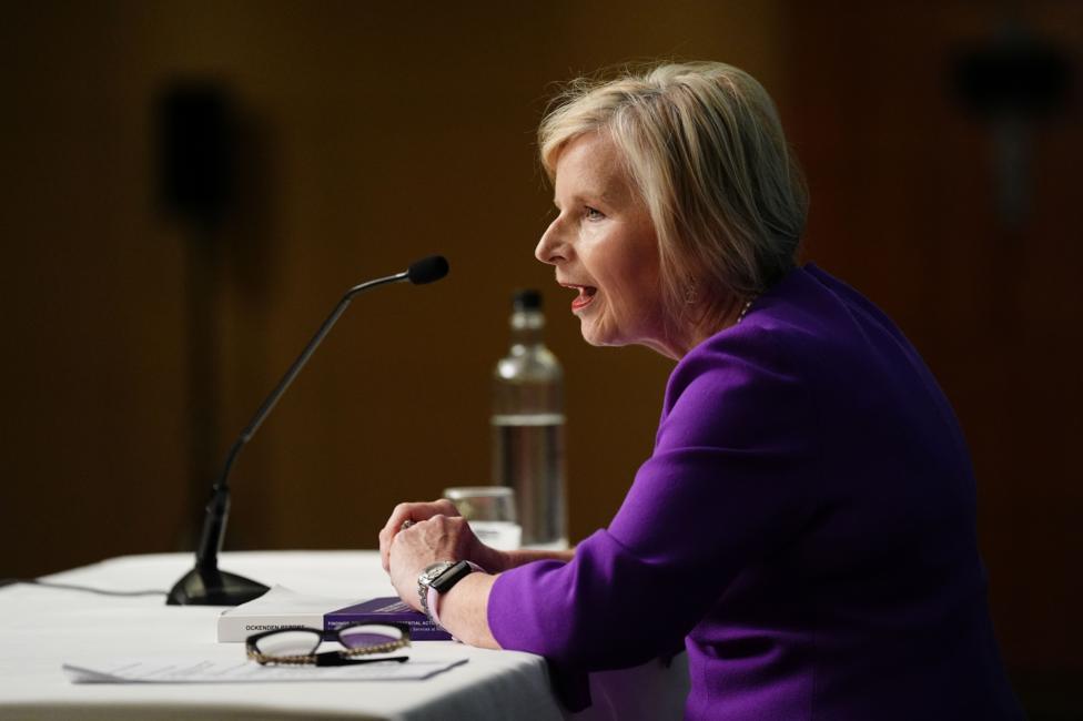 Woman with blonde hair speaking into microphone