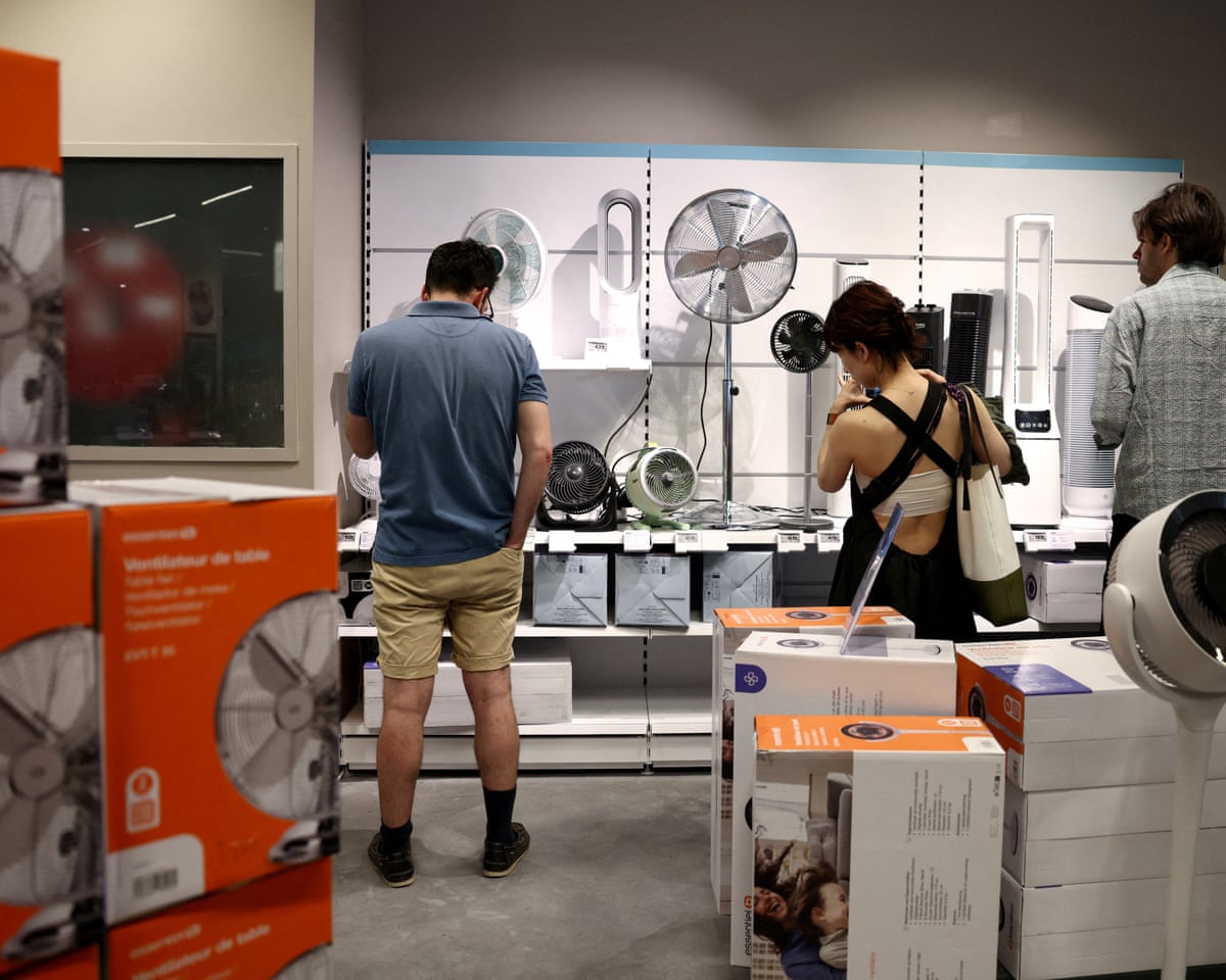 People browse fans and air conditioning units in a homeware store, amid a heatwave in Paris, France.
