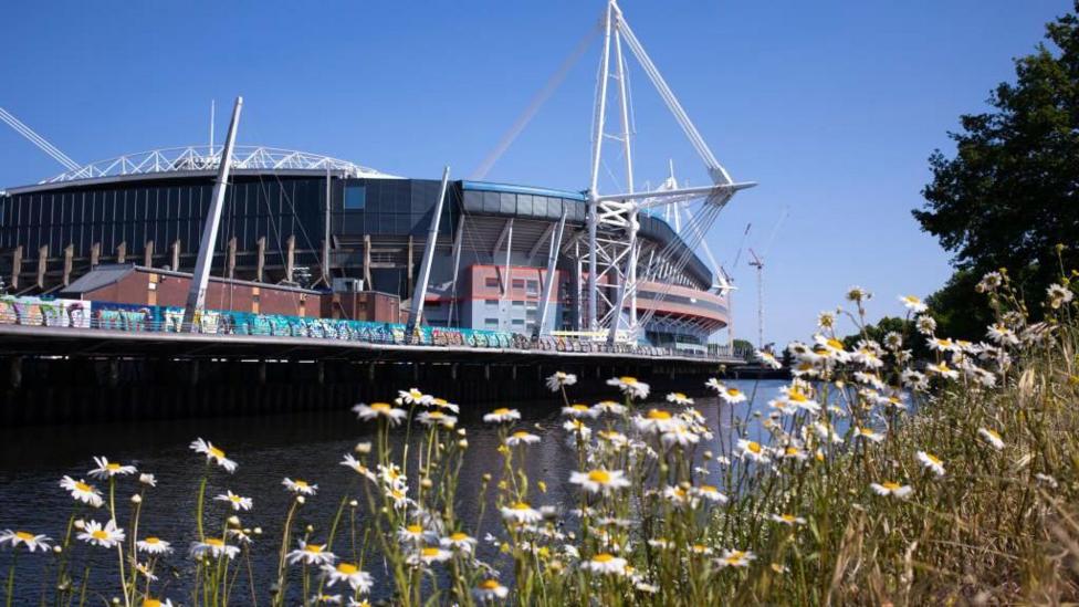 Principality Stadium with the sun shining next to the River Taff.