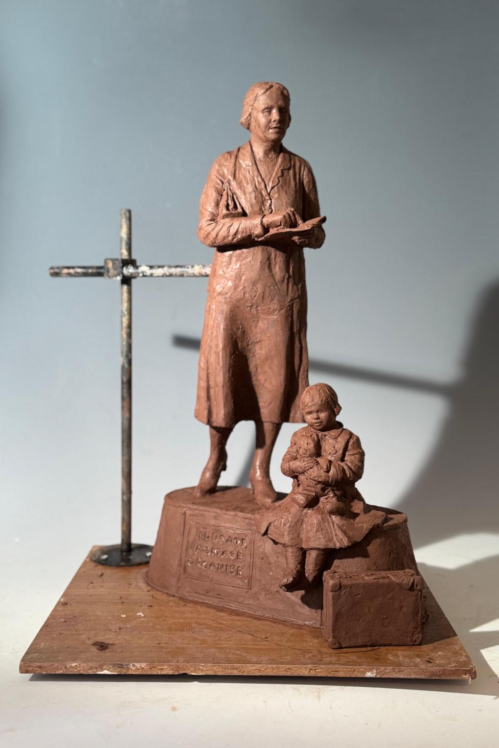 A mini version of the top statue of the woman and child.