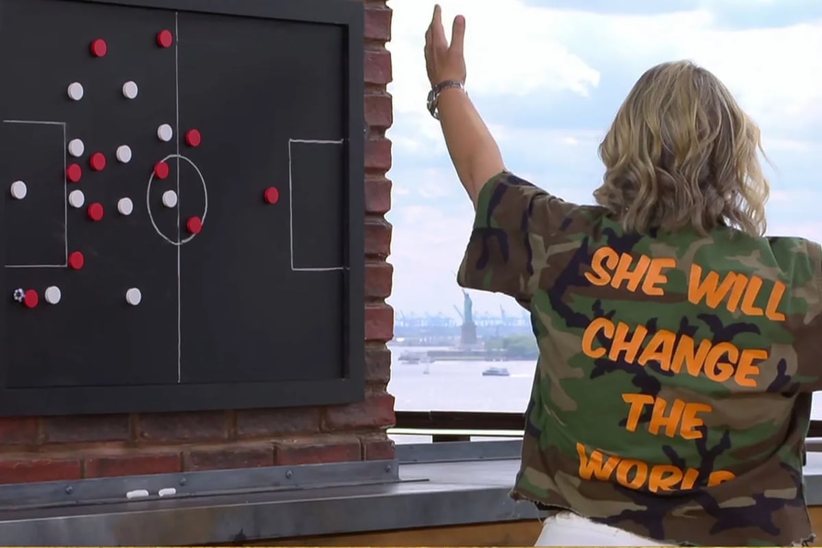 Emma Hayes shows the back of he jacket which says “She will change the world” 