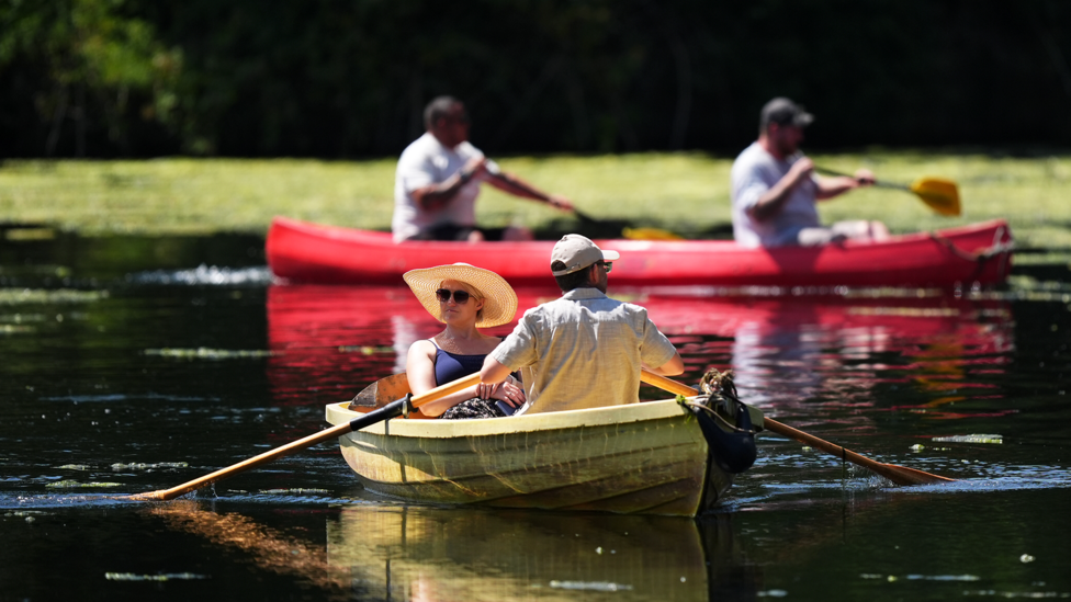 People on the boating lake at Highfields Park, Nottingham. A weather warning for extreme heat covering parts of England and Wales has come into force for just the second time. 