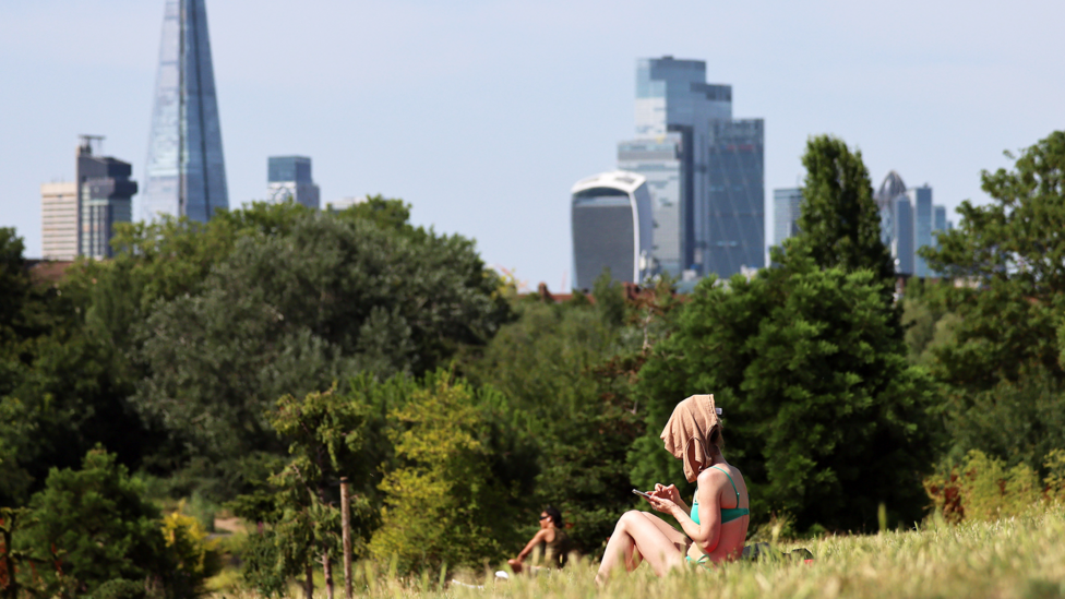 Mandatory Credit: Photo by ANDY RAIN/EPA/Shutterstock (16956441f) A person covers her face from the sun at a park as the UK is set to experience its hottest June day on record during a heatwave in London, Britain, 23 June 2026. 
