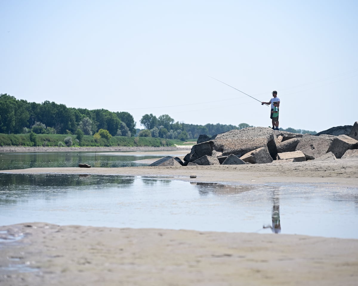 People fish amidst sandbanks and exposed riverbed along the Po River in San Daniele Po, Cremona, northern Italy.