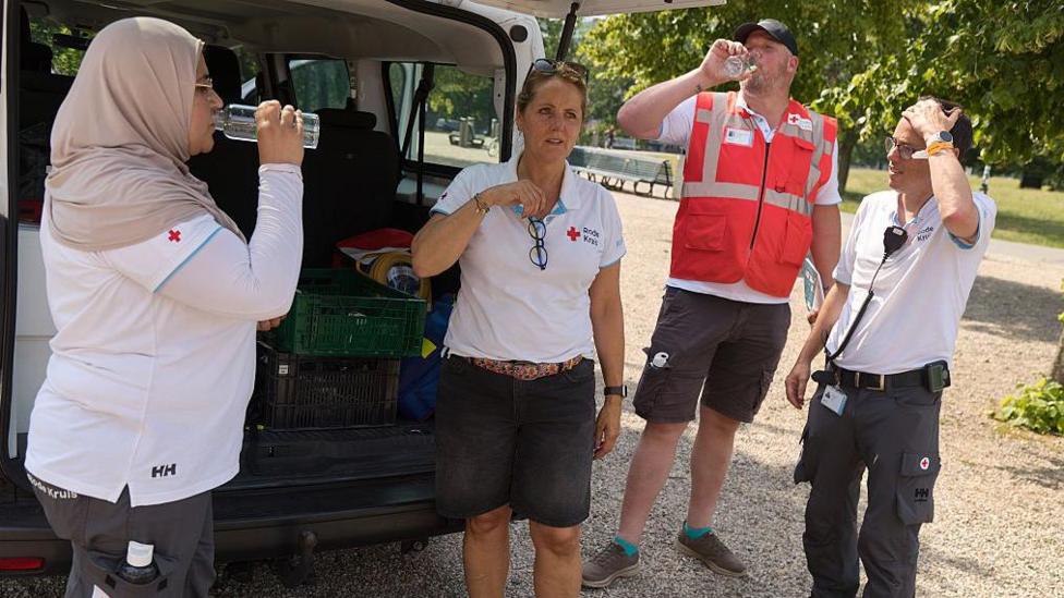 Red Cross volunteers provide water and assistance to homeless and vulnerable people on the street during a Code Red heat alert on June 26, 2026 in The Hague, Netherlands