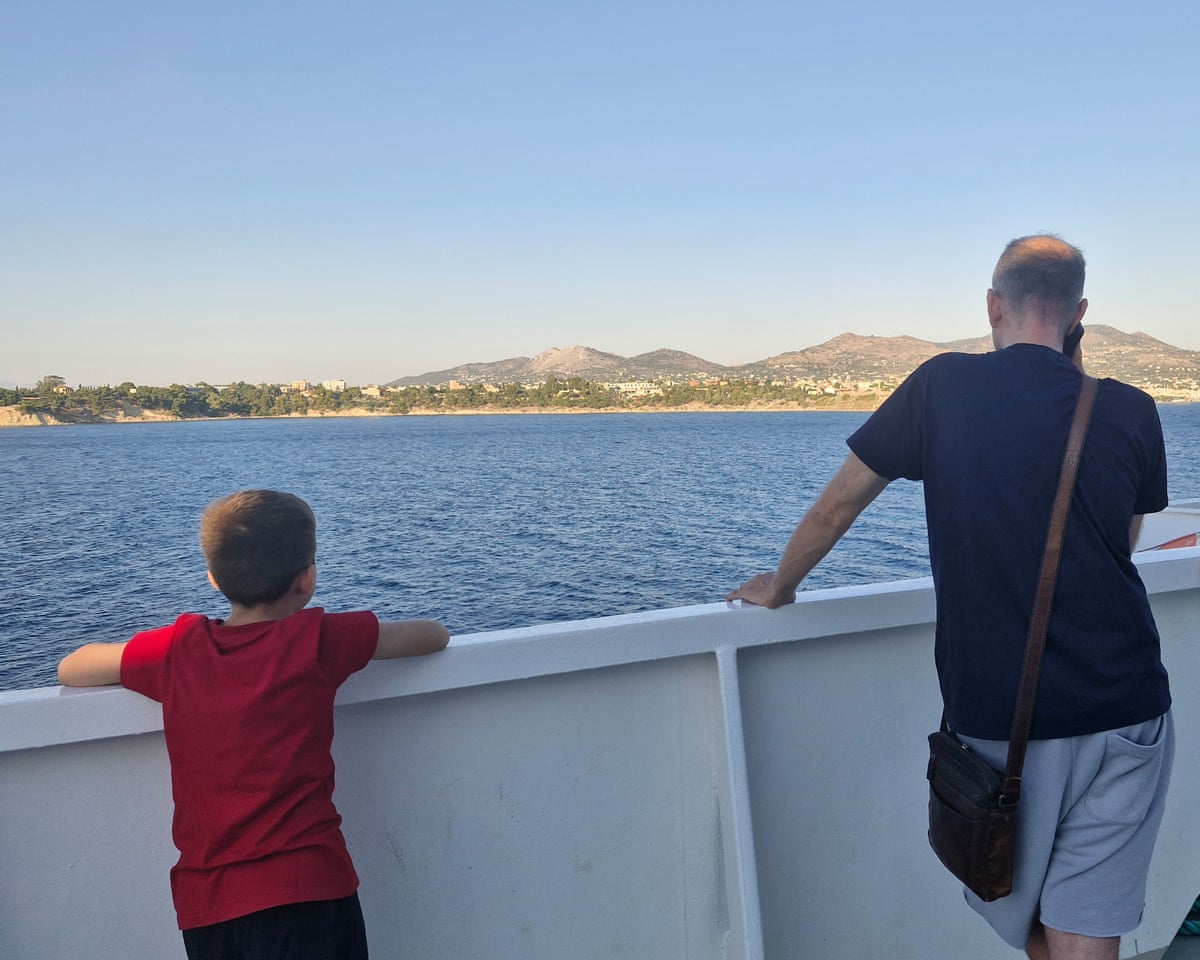 A man and a child looking out from the deck of a ferry