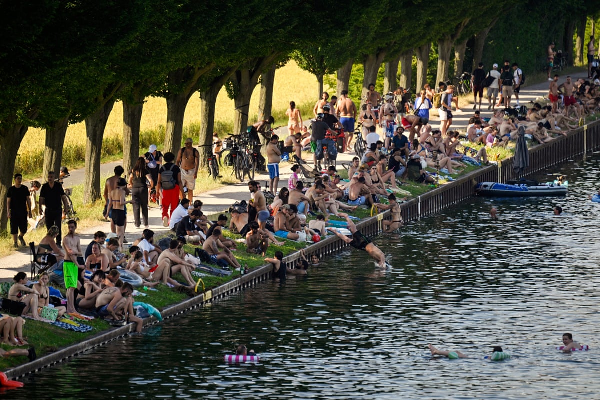 People sit at the side of the Dortmund-Ems Canal in Dortmund, western Germany during a heatwave in Europe.