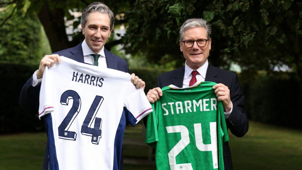 Prime Minister of Ireland Simon Harris and his British counterpart Keir Starmer hold up their respective national soccer team's shirts with their names on their opposite team's shirt at Farmleigh House, in Dublin.