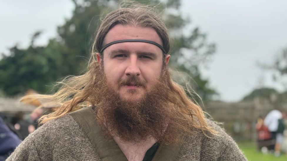A man with long light brown hair and a long beard. 