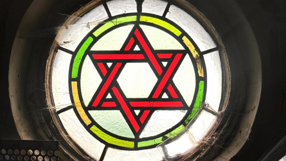 A close up of one of the synagogue's stained circular glassed windows showing the Star of David.