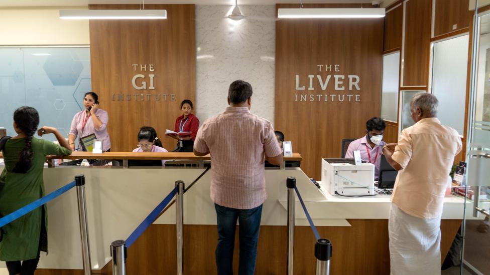 People standing at the reception counter of the Liver Institute in Kerala 
