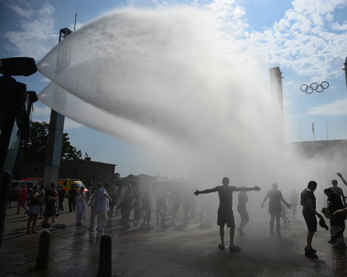 Police use water cannon to spray people with water as the arrive at the Olympic stadium for a concert of US singer Bruno Mars in Berlin, Germany.