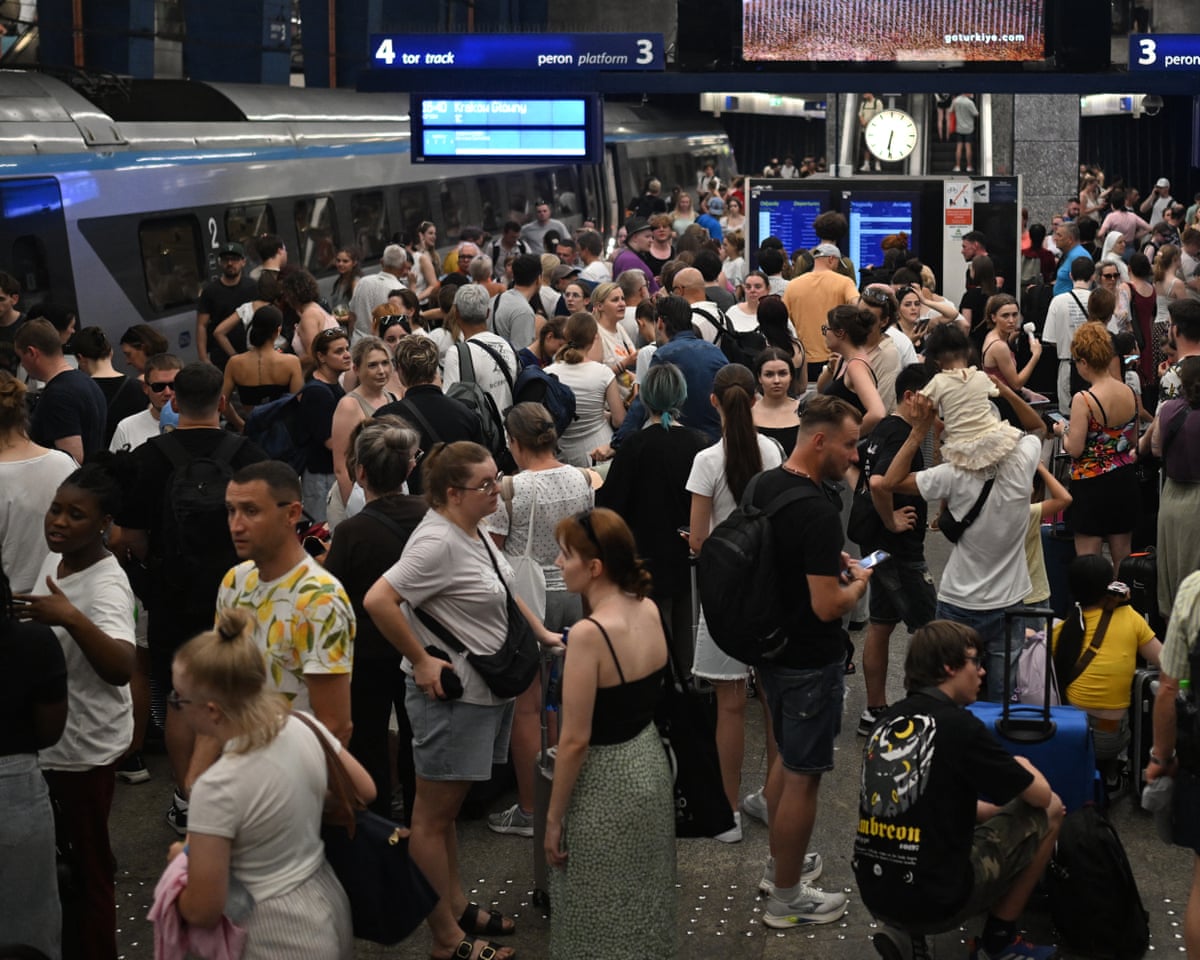 Passengers stand on the platform waiting for trains delayed due to the heatwave at Warsaw Central railway station in Warsaw, Poland.