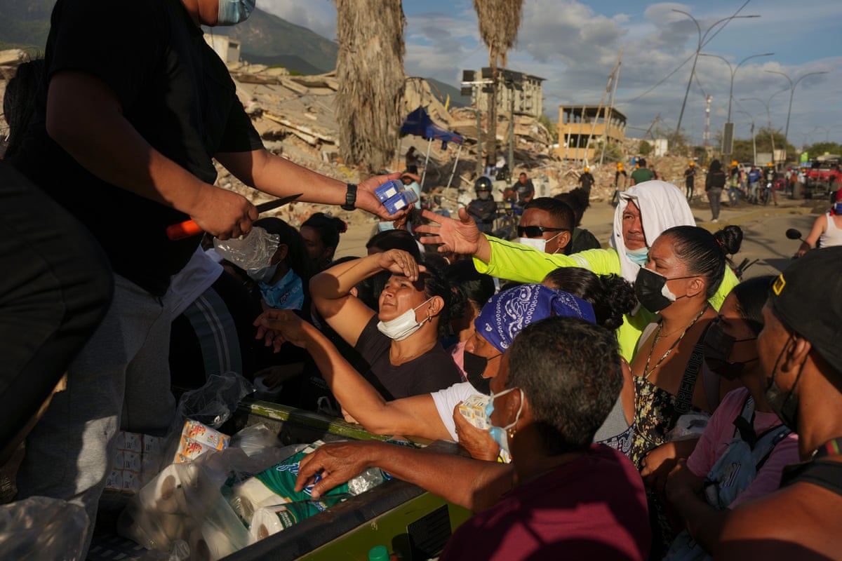 People affected by the earthquakes line up for food in La Guaira.