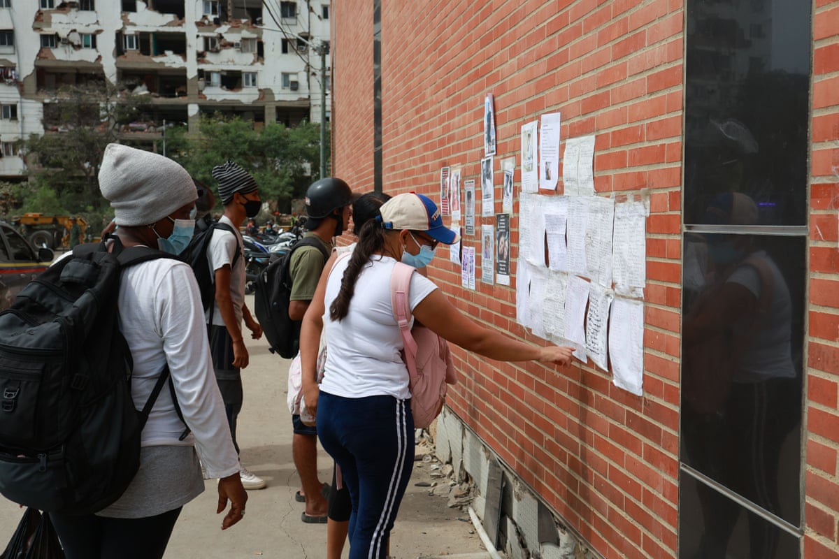 Family members search through lists of hospitals and missing persons in La Guaira following the earthquakes.