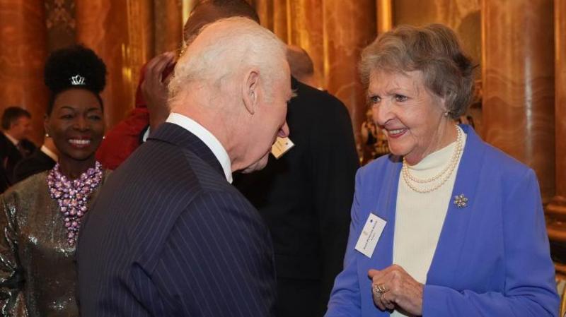 Penelope Keith is shown in conversation with King Charles at a reception in 2024