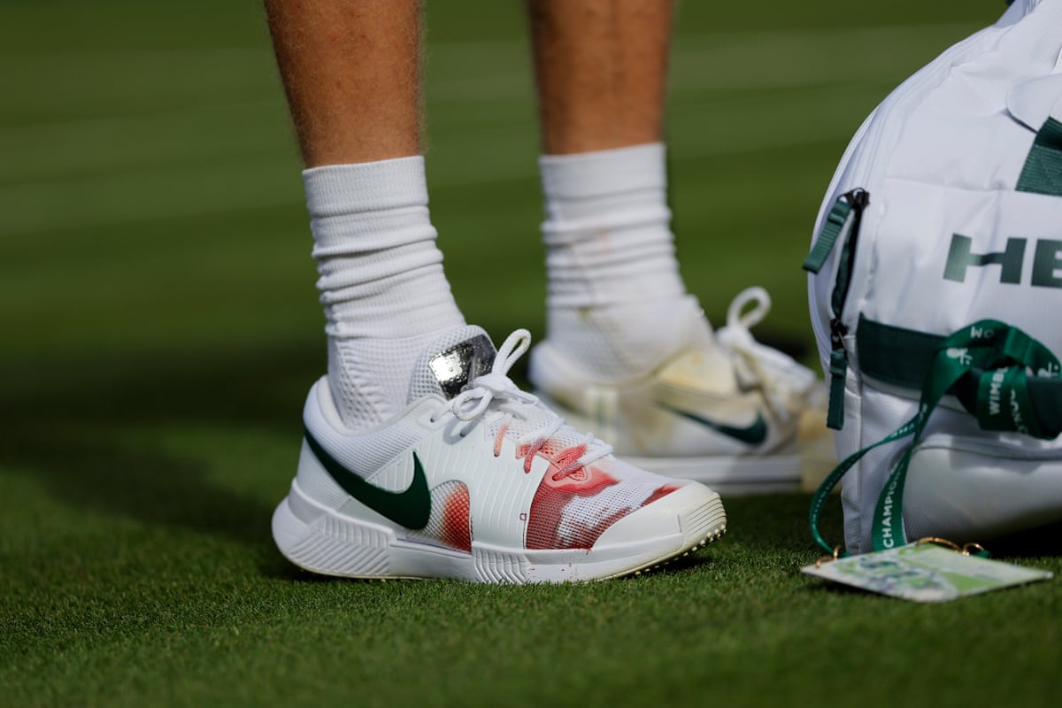 Blood is seen through Jannik Sinner's shoe