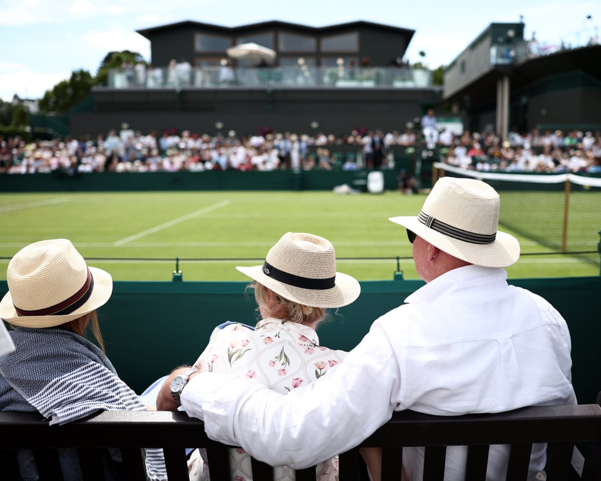 Spectators watch on the out courts at Wimbledon