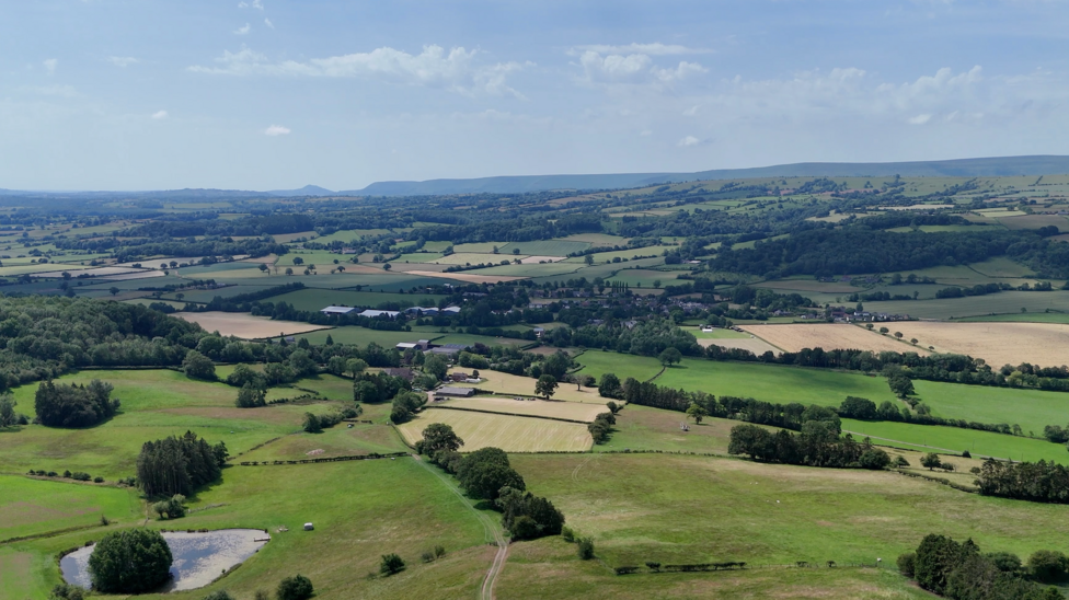The view of the Golden Valley shows farmland, hedgerows and the black mountains in the distance