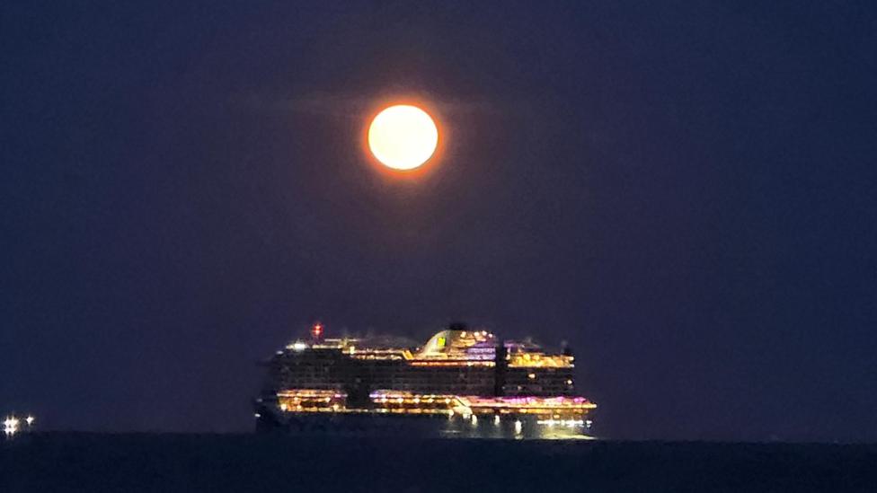 Gosport with cruise ship passing glowing Strawberry Moon