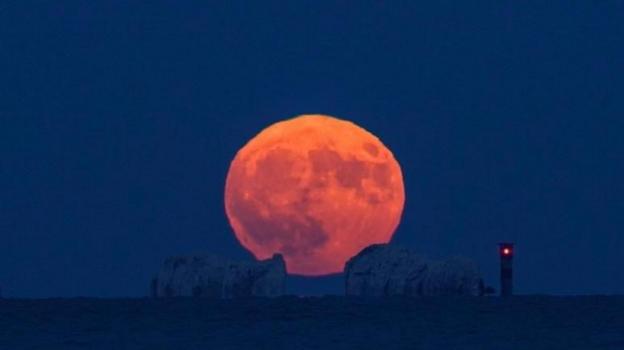 Full strawberry moon rising over the needles on the Isle of Wight.