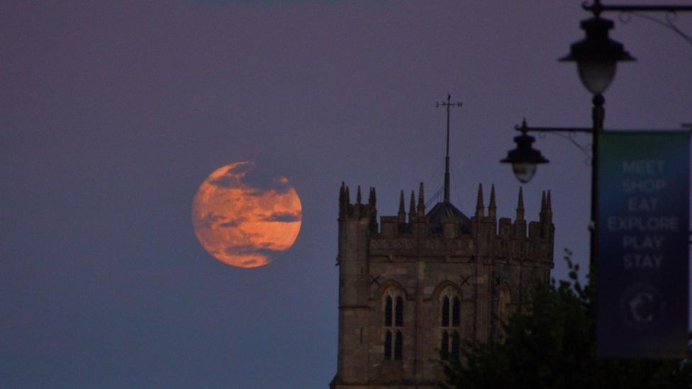 Strawberry Moon rising beside Christchurch Priory