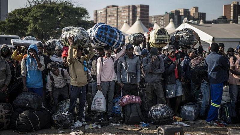 Migrants lining up near a bus to take them away