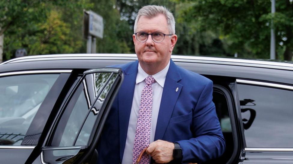 Donaldson has short grey hair and is wearing a blue suit as he gets out of a black car.