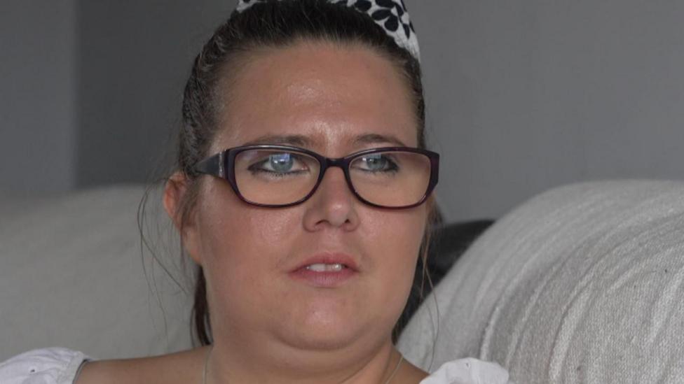 A woman in a white shirt with rectangular glasses.