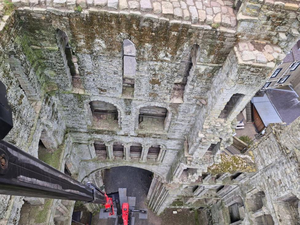 A view down the inside of Kelso Abbey from a cherry-picker - it is surrounded by very mossy brickwork