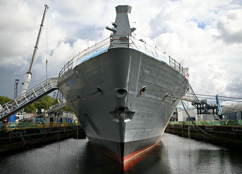 A large ship, viewed bow on, in a fitting out dock