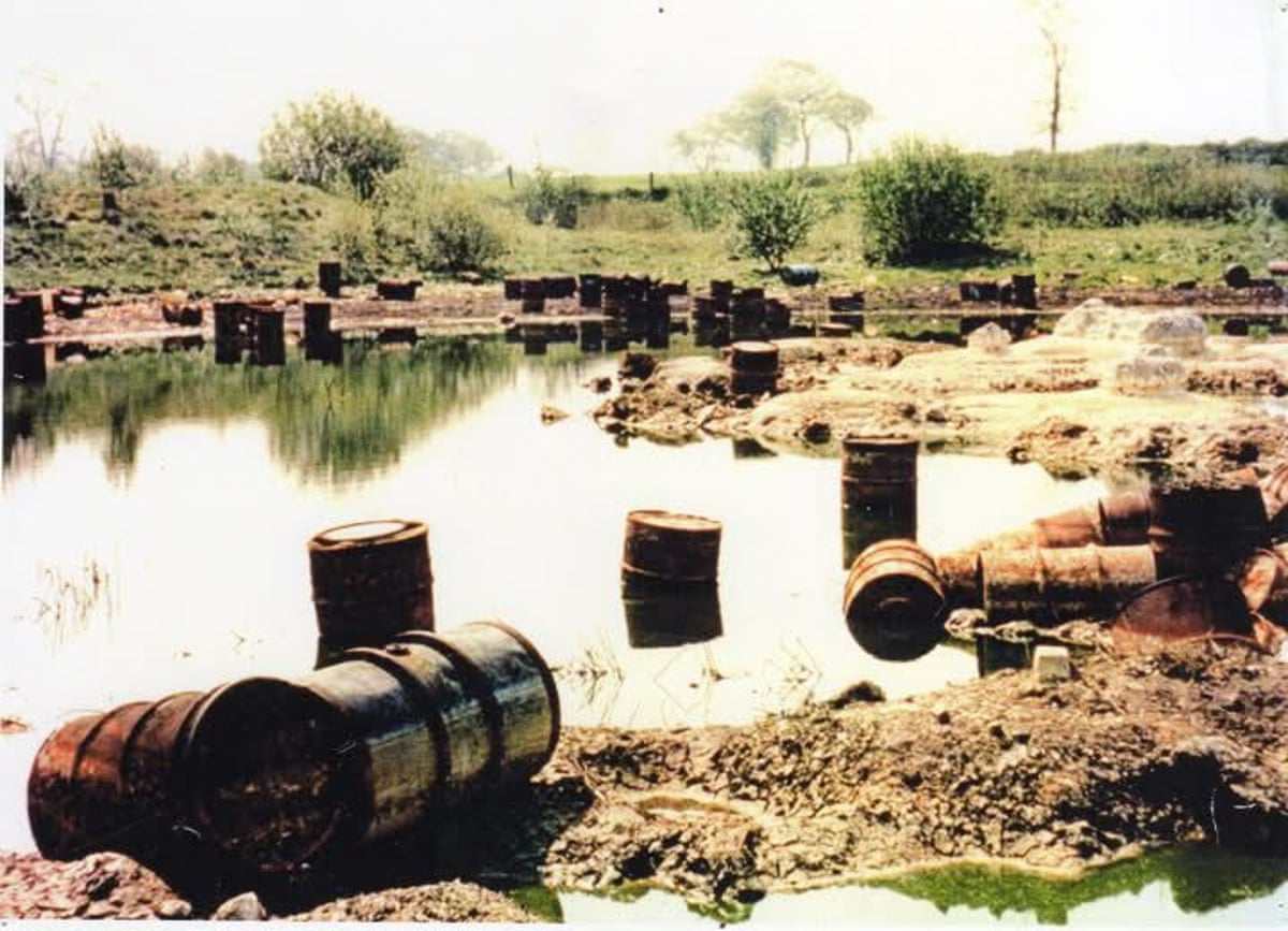 Chemical drums sitting in and around a lake