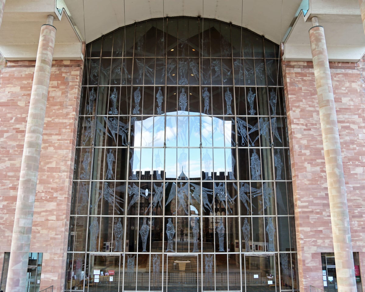 A huge arched window of panels featuring engravings of saints and angels