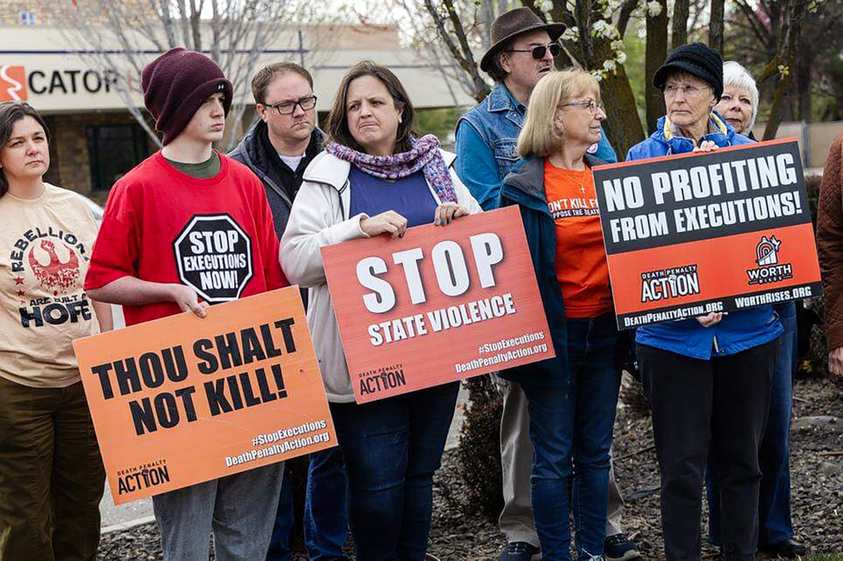 people hold signs against the death penalty