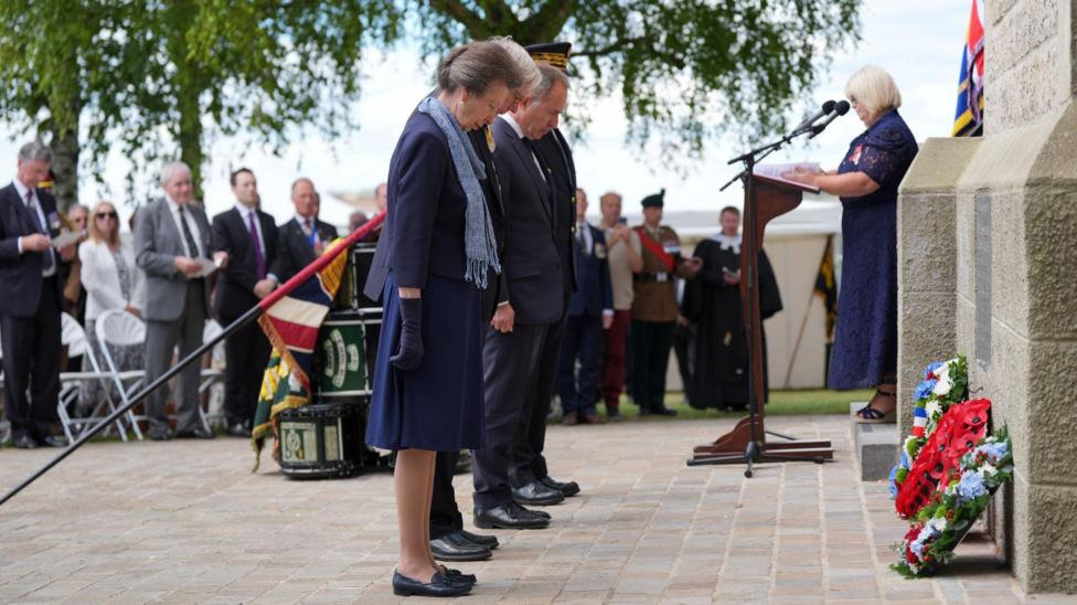 Princess Anne bowing her head in front of the wreaths laid at the base of the Ulster Tower.