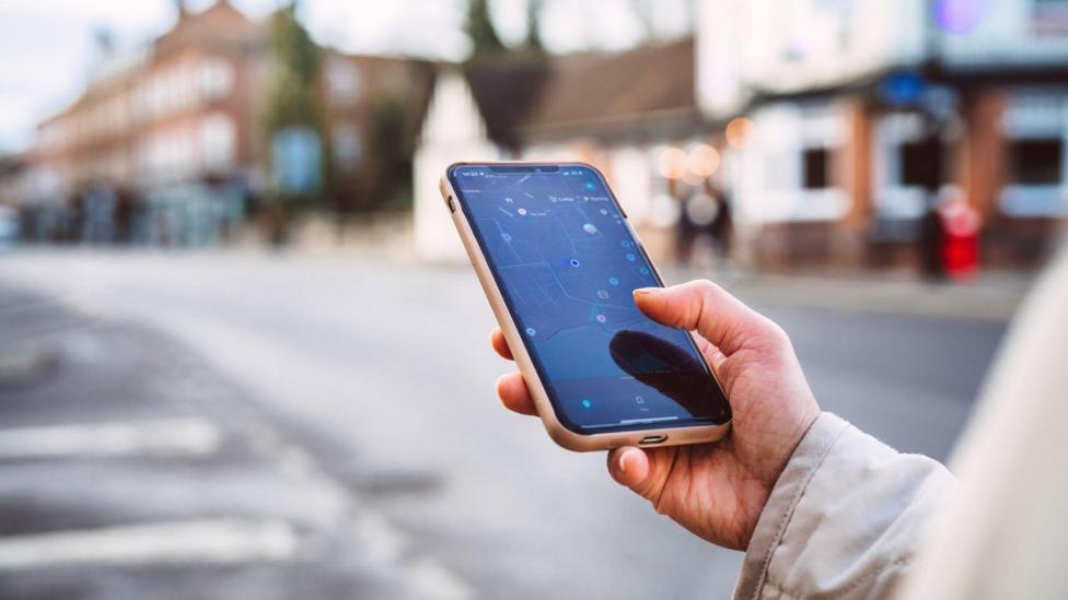 Close up of a hand holding a phone with a map on it