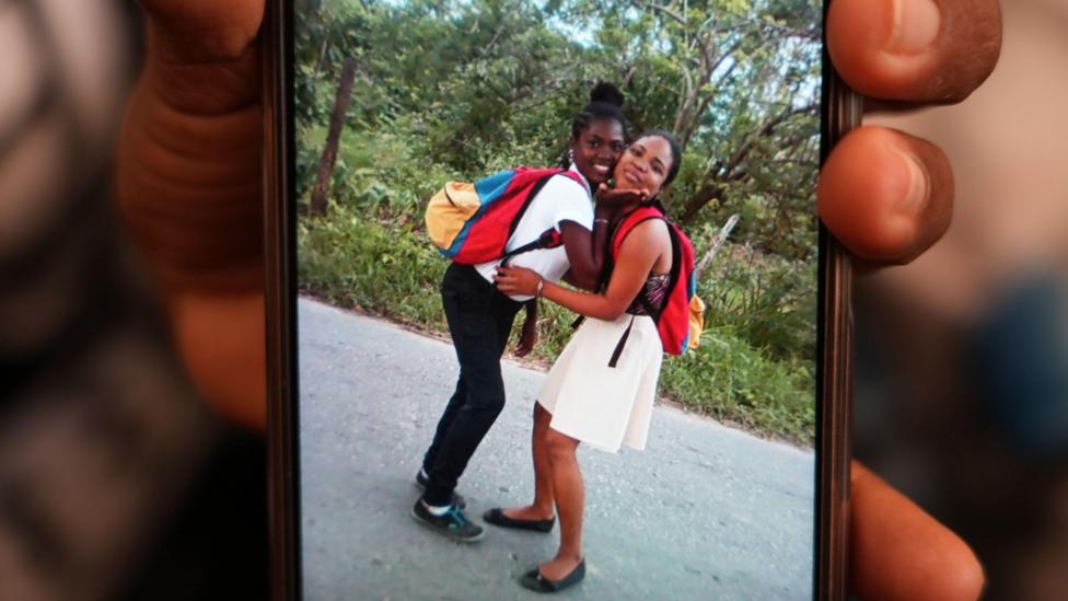 Andreína holds a phone with a picture of her and sister Ana Luz, Kleiber's mother, who is still missing