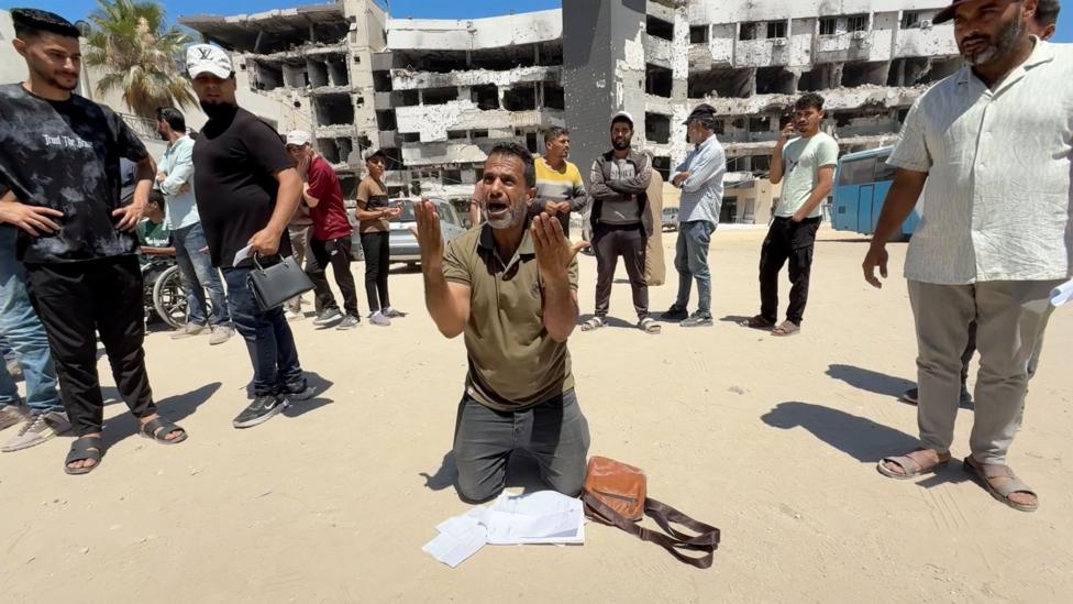 A man waiting for a medical evacuation kneels outside al-Shifa hospital in Gaza City, northern Gaza