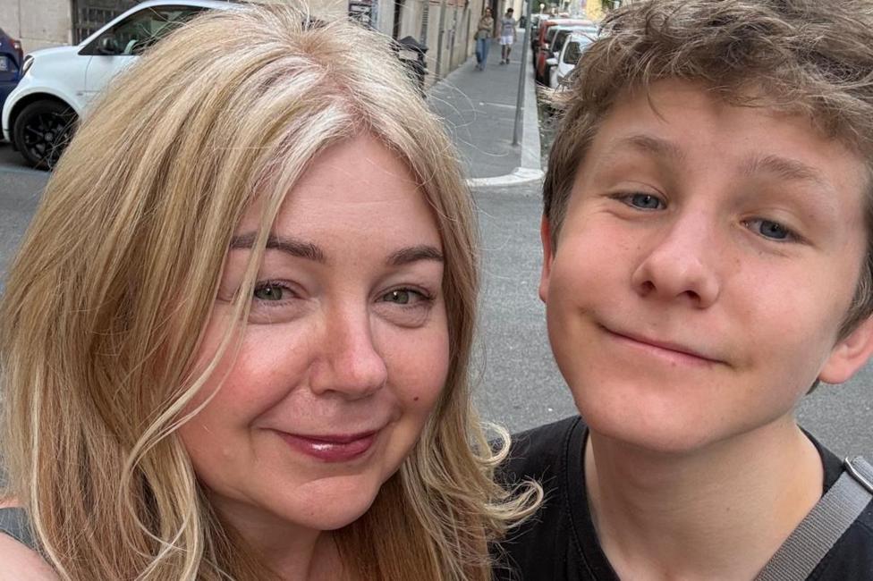 A selfie photo of lady with blonde hair and her teenage son smiling at the camera during their trip to Rome.