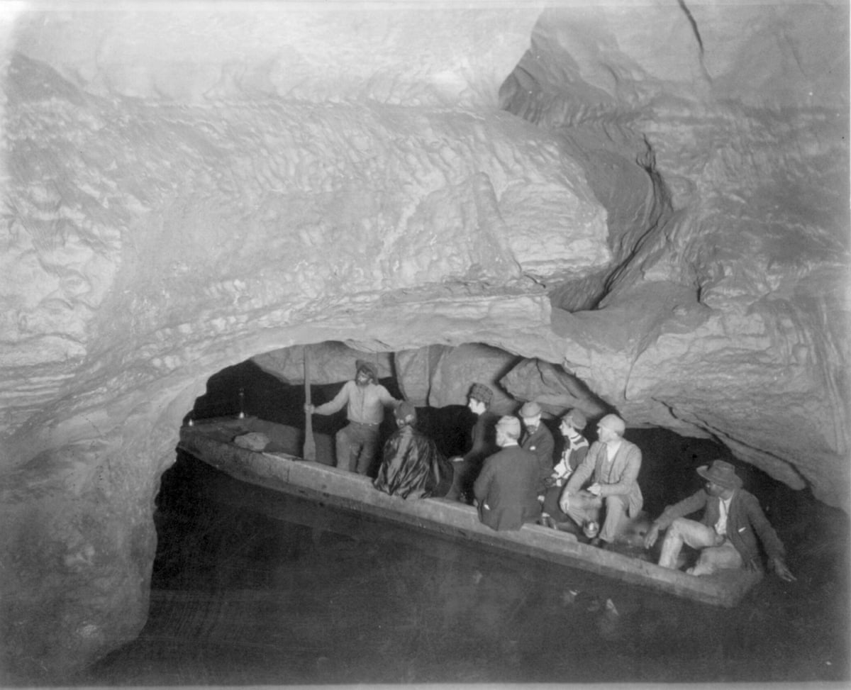 Historical image of people on a boat in a cave