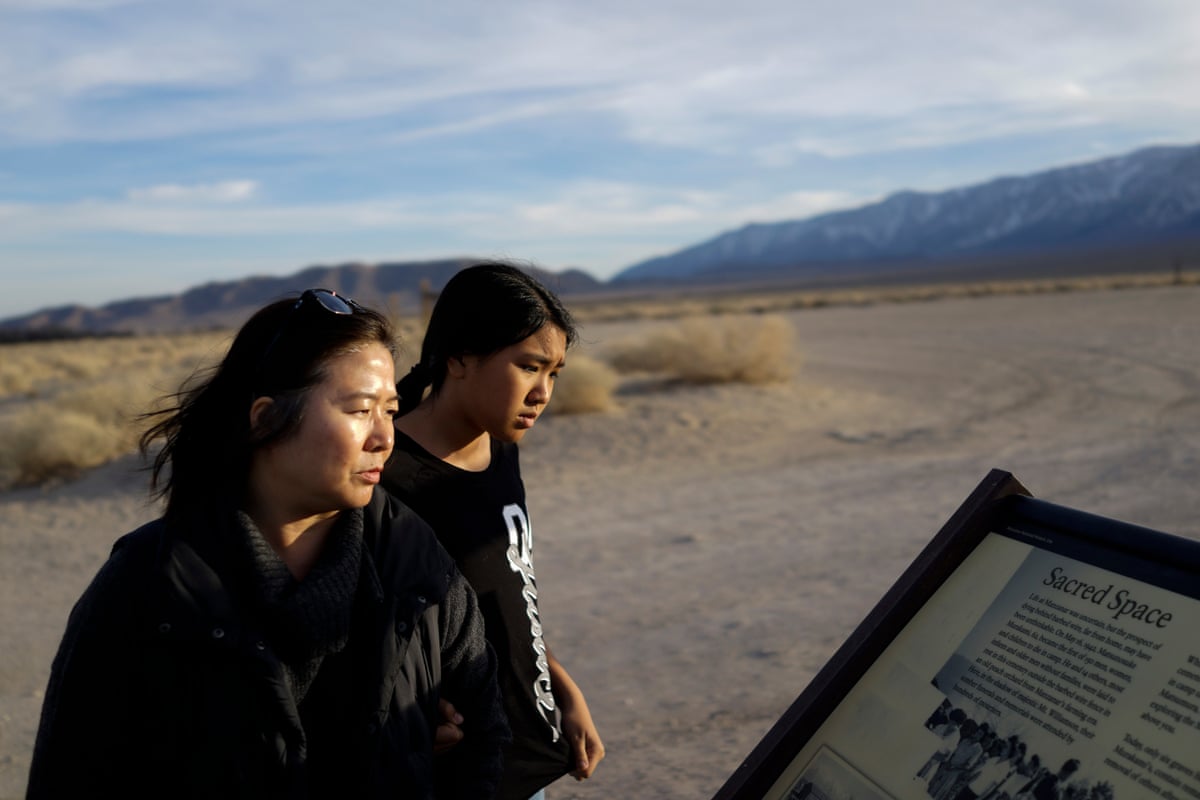two people look at an outdoor sign at a national historic site
