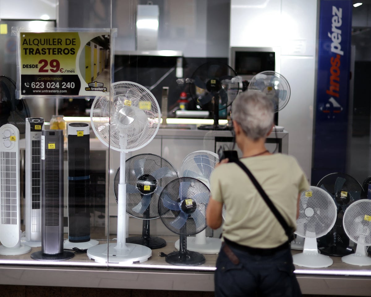 A woman looks at a display of fans in a shop window in Madrid.