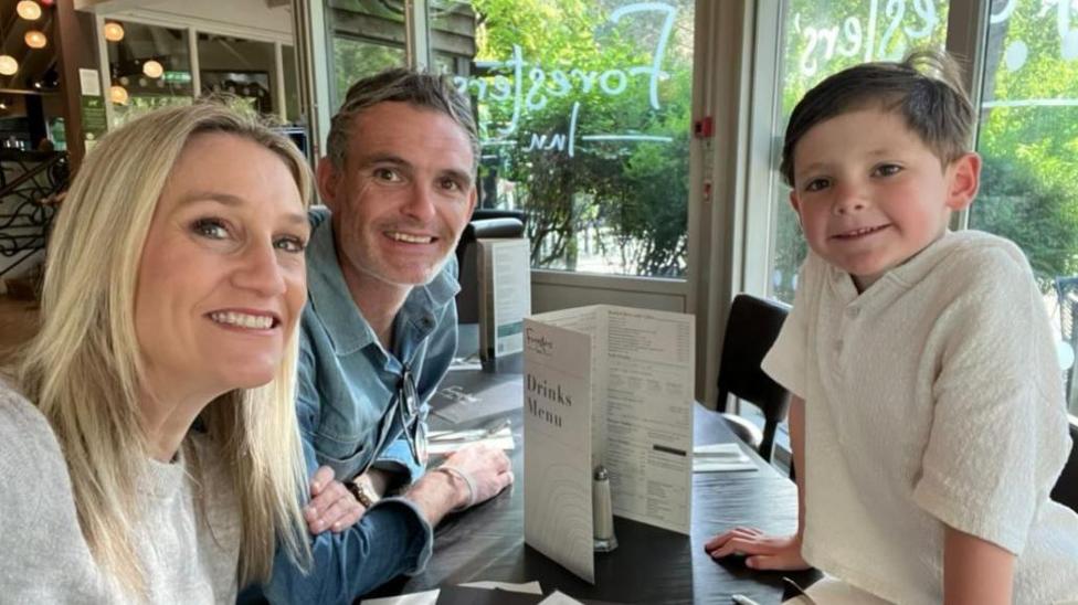 Roxie Westwood with her husband and son smiling around a table