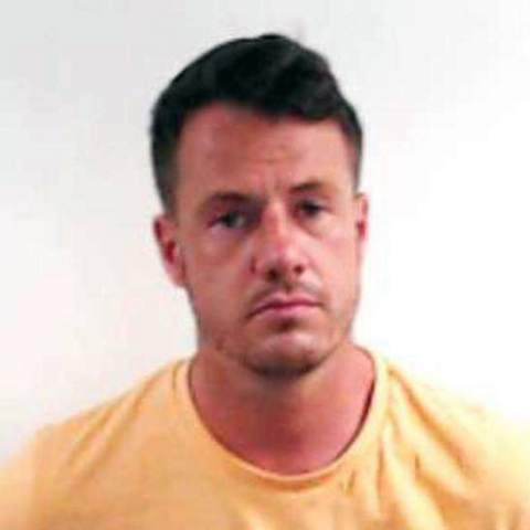 A mugshot of Cameron Ross, looking straight at the camera wearing a yellow T-shirt against a white background.