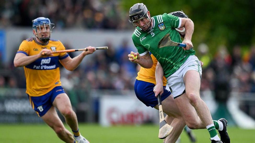 Diarmaid Byrnes of Limerick is tackled by Tony Kelly of Clare