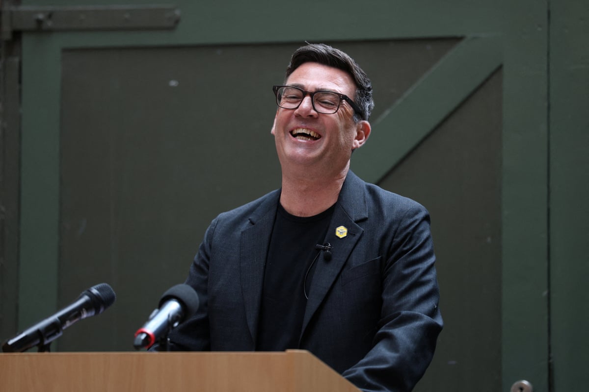 Andy Burnham laughs as he delivers a speech