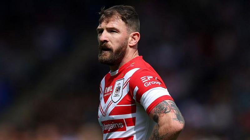 St Helens hooker Daryl Clark, in red and white, has hands on hips as he watches play develop.